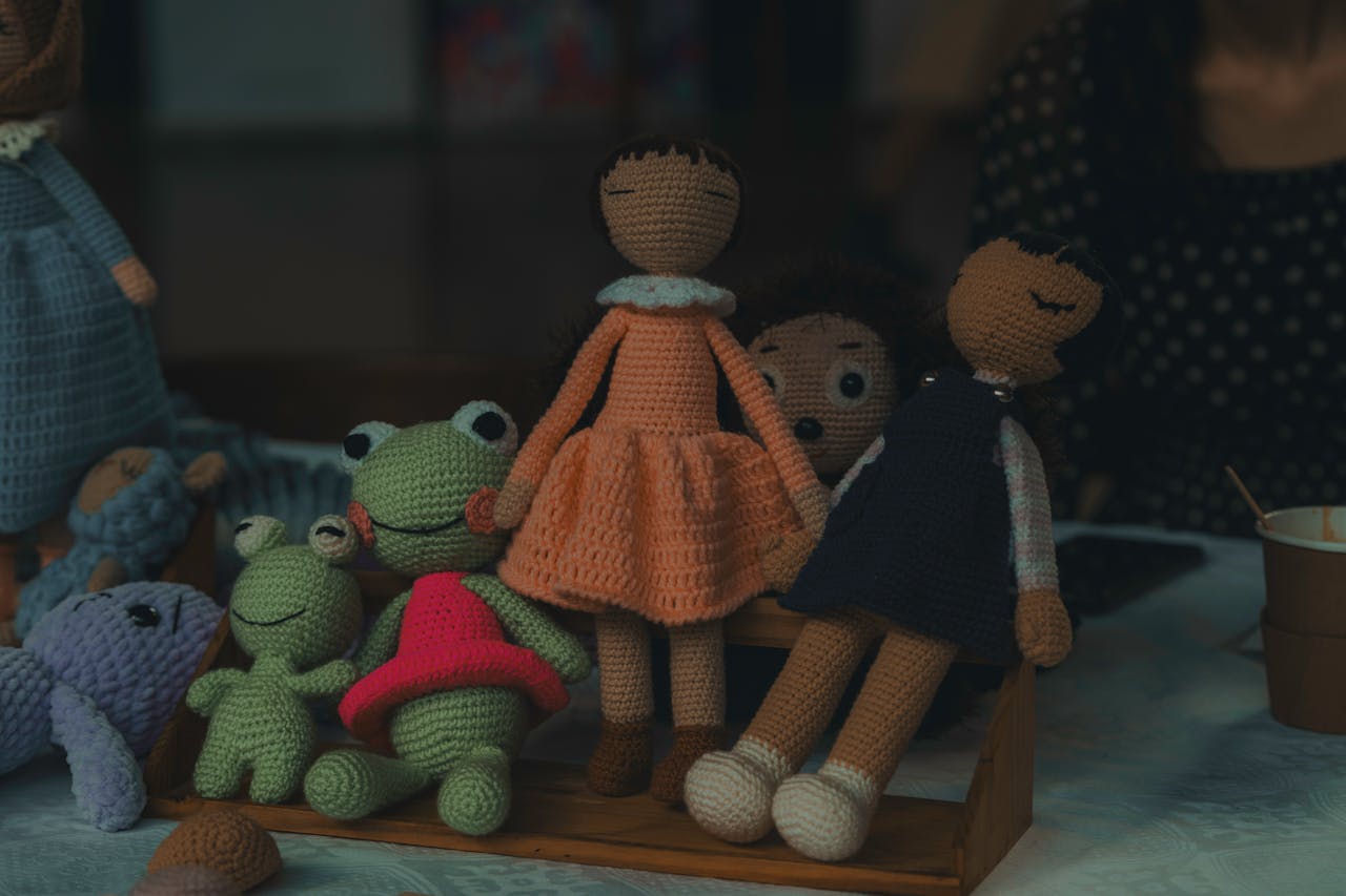 A delightful set of handmade knitted dolls and stuffed animals on display, showcasing intricate craftsmanship.